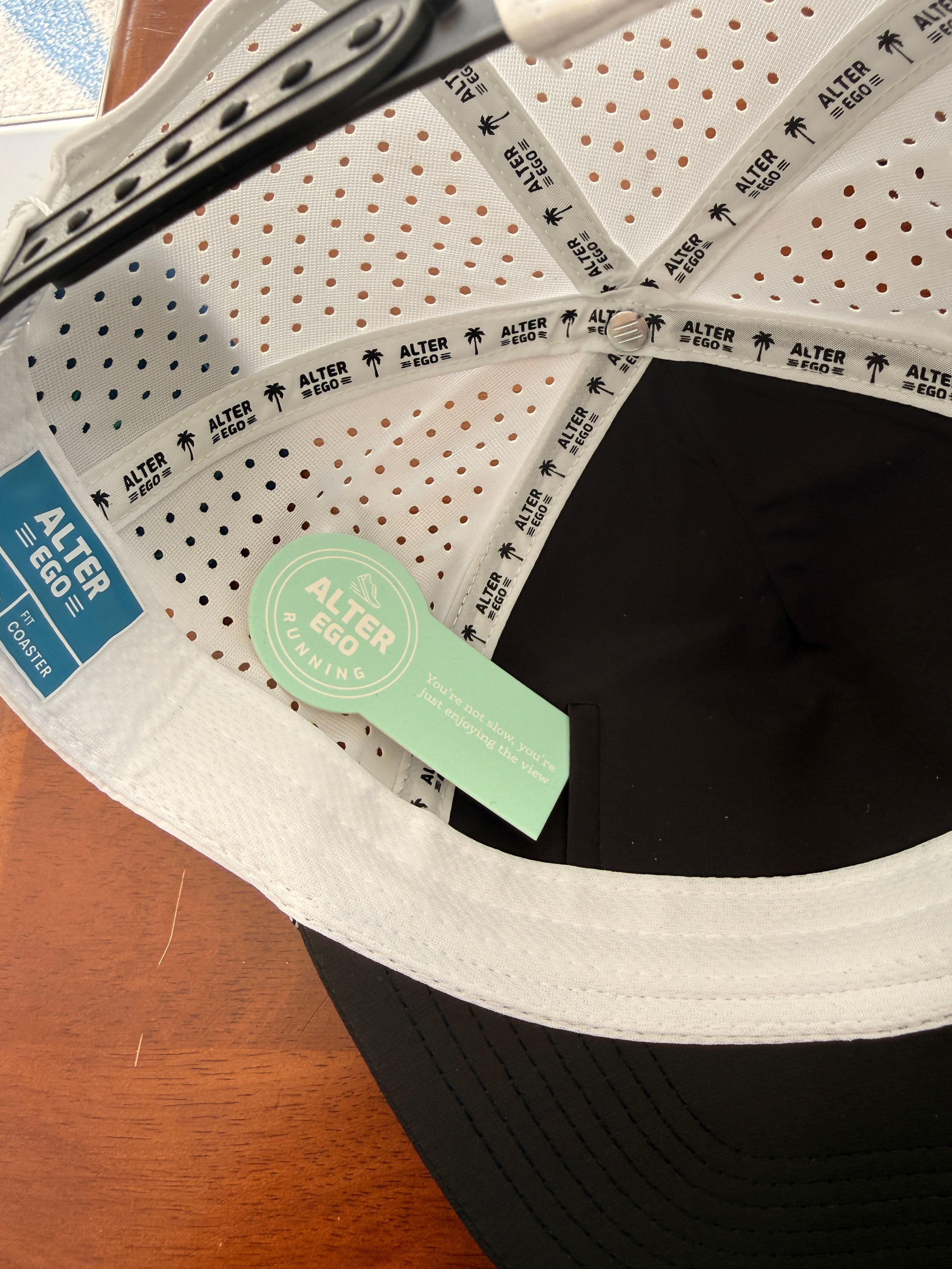 The hidden AER Run Pocket built into the underbrim of the Alter Ego Coaster Splash Classic Black White Palm hat, alongside its Fit: Coaster size label
