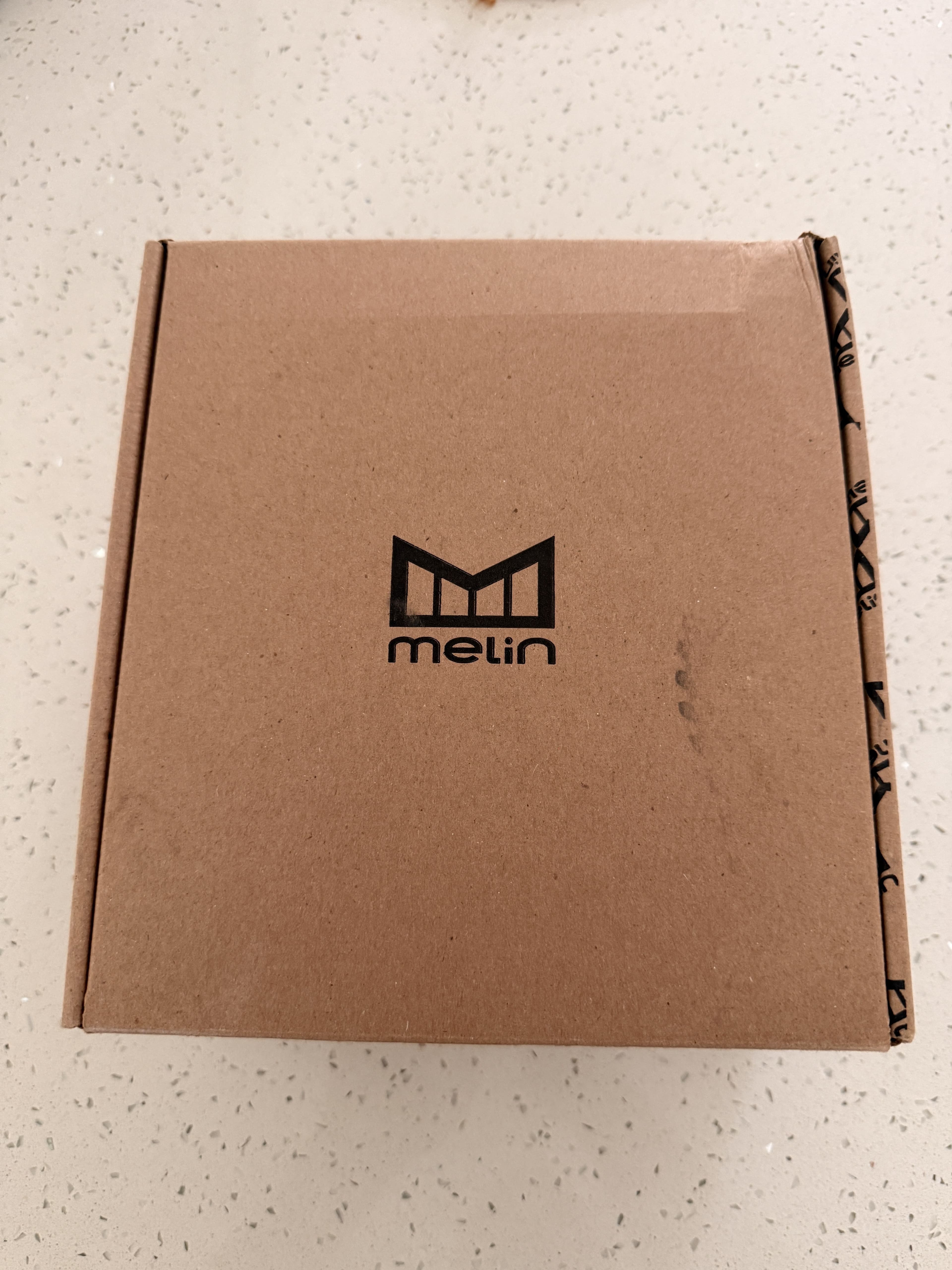 Unopened Melin shipping box with the brand's M logo, delivered to the front door