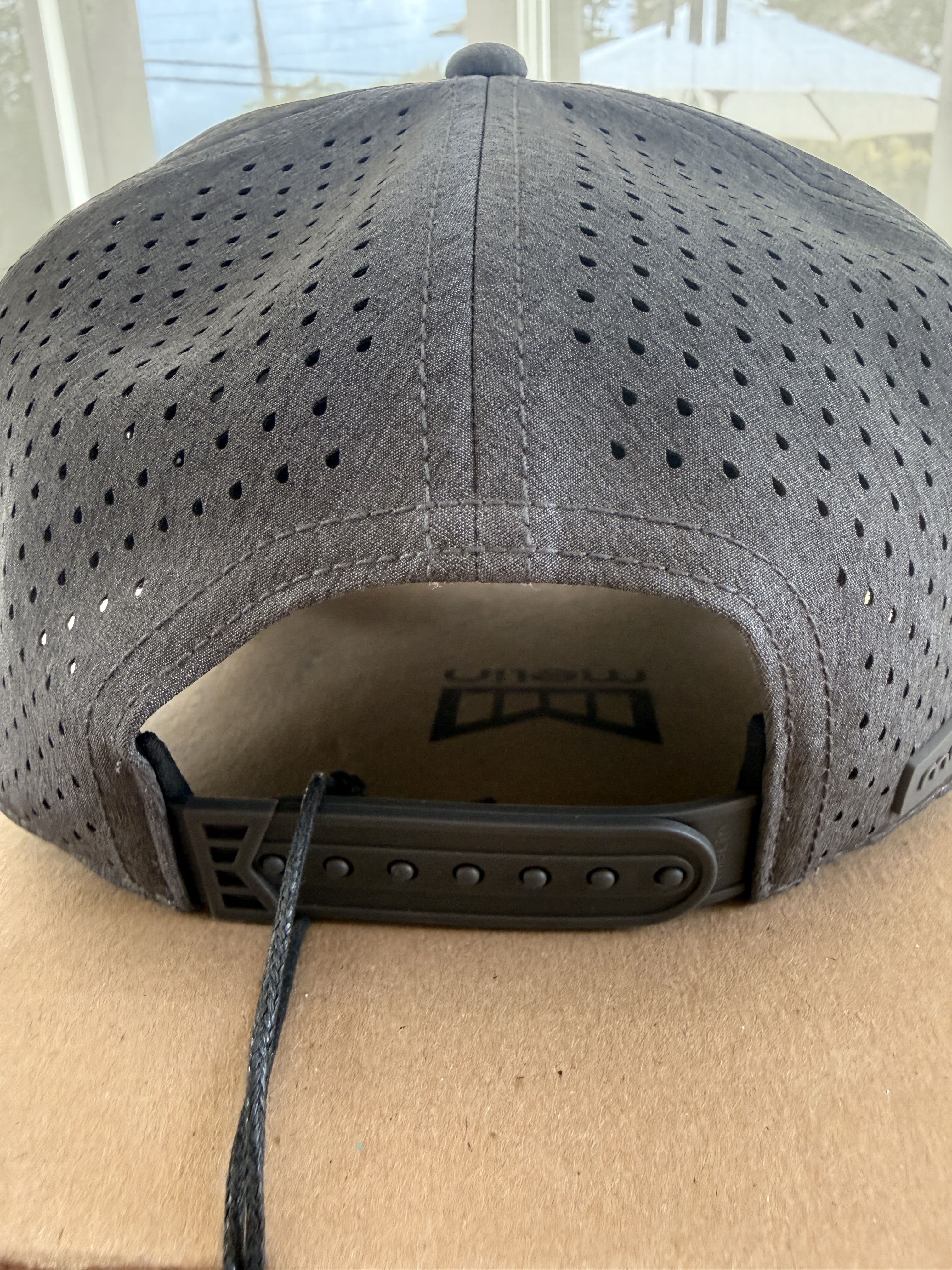 Interior view of the hat's adjustable snapback closure and printed Melin wordmark